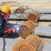 A welder performs a wire welding process outside.