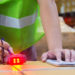 A warehouse worker uses a barcode scanner as part of taking inventory.