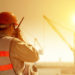 A construction worker uses his radio while working in high heat outdoor conditions.